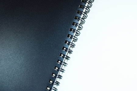 Diagonal Black Spiral Notebook on White Backgroundの写真素材