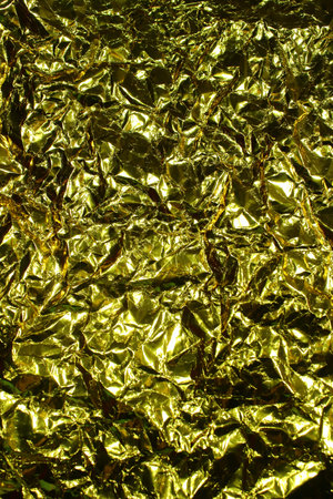 Full Frame Crumpled Gold Metallic Paper Texture. Shiny Abstract Foil Background for Luxury...
