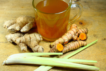 Herbal turmeric and ginger tea with lemongrass on wooden table, healthy traditional drink rich in...