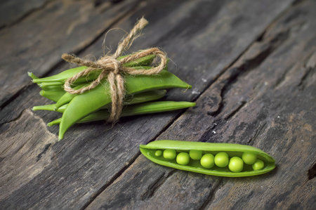 Green peas on old wooden backgroundの写真素材