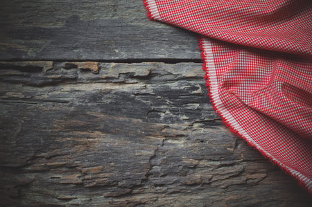 Red fabric on wooden table background