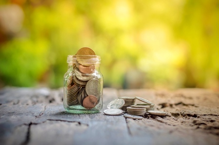 Saving money coins in the bottle on wooden backgroundの写真素材