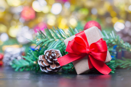 Close up of handcraft gift box with red ribbon and pinecone on wooden table for Christmas or New...