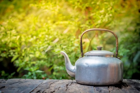Kettle on wooden table in the morningの写真素材
