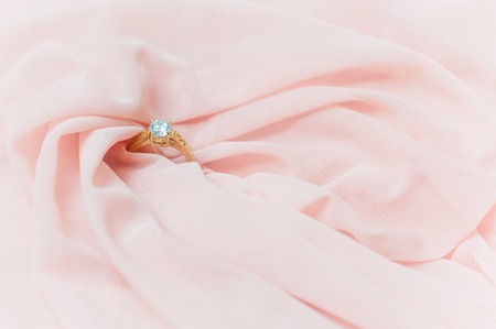 Close up of diamond ring on pink fabric for valentine day or wedding backgroundの写真素材