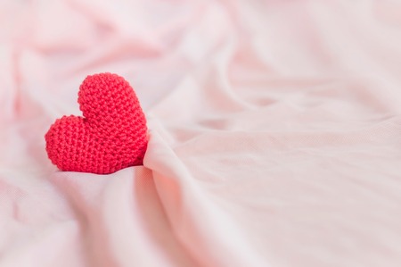 Close up of red heart handmade on pink fabric for valentine's day or wedding backgroundの写真素材