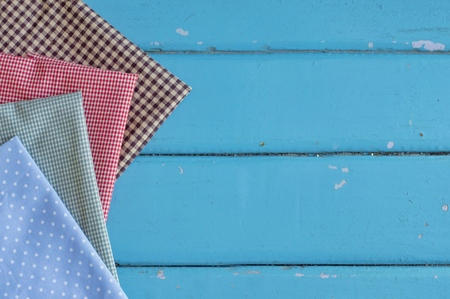 Multicolored fabric on blue wooden table for sewing backgroundの写真素材