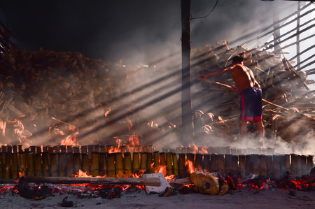 Worker still make in borned the filled ingredients bamboo tubes with the coconut shellの写真素材