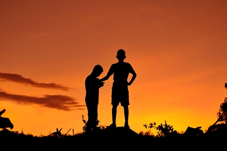 Silhouette of children playing in the forestの写真素材
