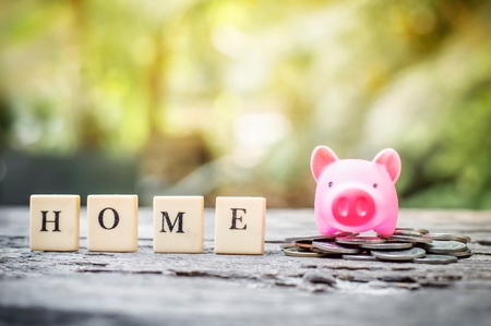Business concept, saving coins with pink piggy bank for homeの写真素材