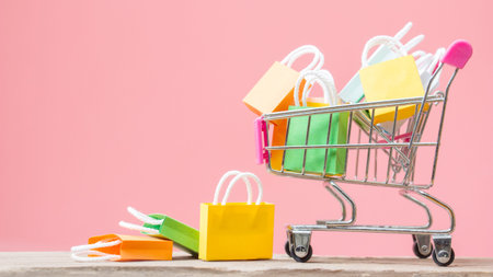 Shopping bags in a shopping cart with pink background.