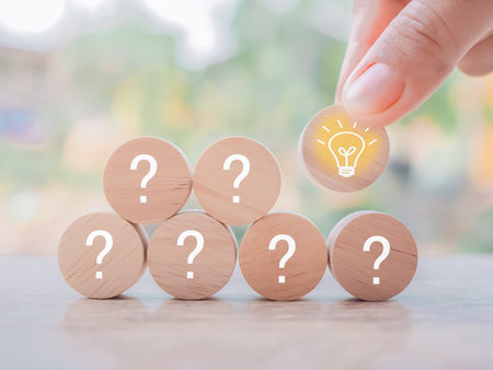Close up hand arranging wooden block with light bulb and wooden block with question mark for leadership, creative, idea, innovation concept.の写真素材