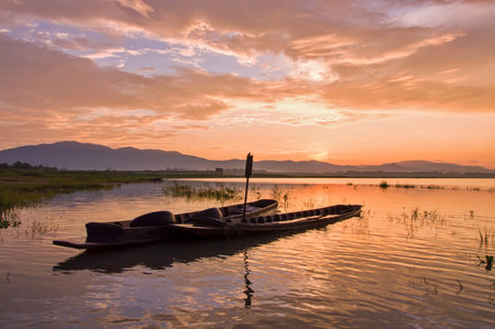 Fisherman boat with sunrise sky in the lakeの写真素材