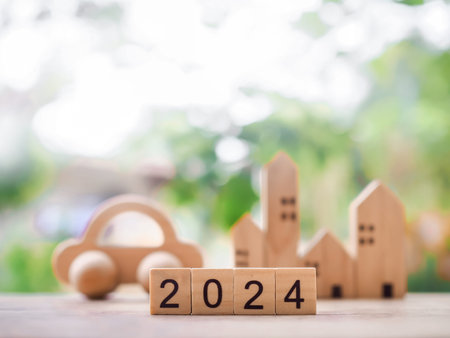 Close up of wooden block number 2024 with miniature house and toy car background. The concept of...