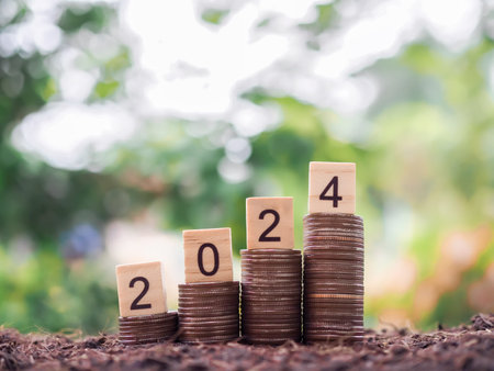 Wooden black with number 2024 on stack of coins. The concept for saving money, business financial...