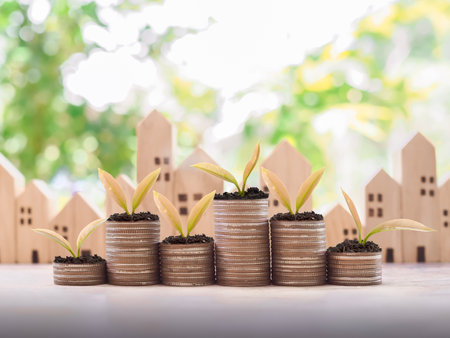 Plants growing up on stack of coins for Investment property concept. Saving money for buy a house.の写真素材