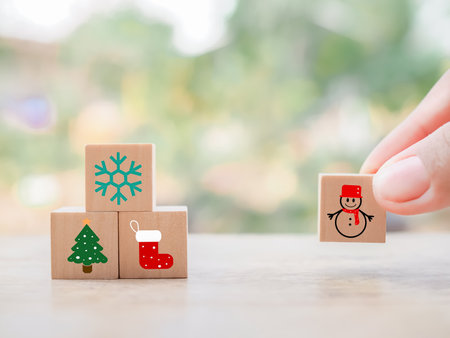 Close up hand arranging Christmas icons for Christmas decorations background.の写真素材