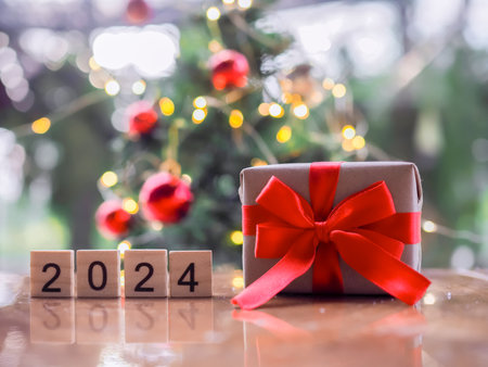 Wooden block number 2024 and gift box with Christmas light bokeh background. Merry Christmas and Happy New Year 2024の写真素材