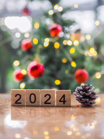Wooden block number 2024 and pinecones with Christmas light bokeh background. Merry Christmas and Happy New Year 2024の写真素材