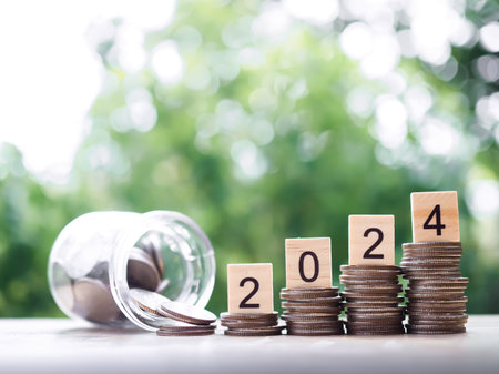 Wooden block with number 2024 on stack of coins. The concept of saving money, Financial, Investment and Business growing in new year 2024.の写真素材