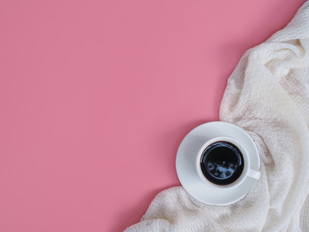 A coffee cup and white sweater on pink background.の写真素材