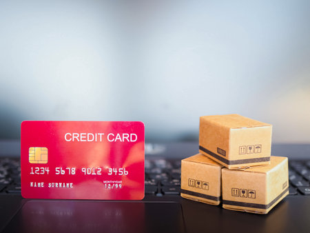 Boxes and Credits cards on a laptop keyboard. Concepts about online shopping that offers home deliveryの写真素材