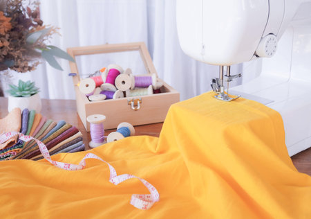 Close up of sewing machine working with yellow fabric,  stitch new clothing.