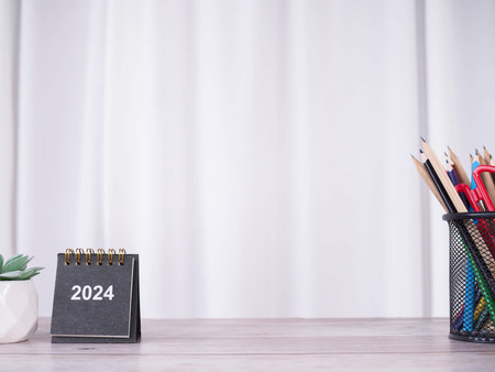 Creative desk with 2024 calendar, cactus and colorful stationery. Copy space for text, Office workspace concept.の写真素材