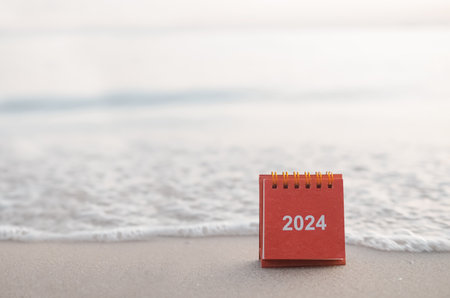 Close up 2024 desk calendar on the beach in the sunset time. Resolution, Goal, Action, Planning, and manage to success business.の写真素材