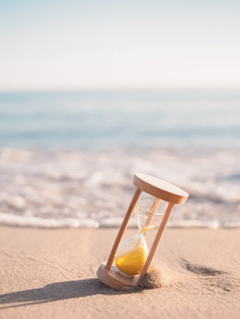 Hourglass on the beach in the sunset time. The concept about countdown to Summer, Travel, Vacation and Relaxation.の写真素材