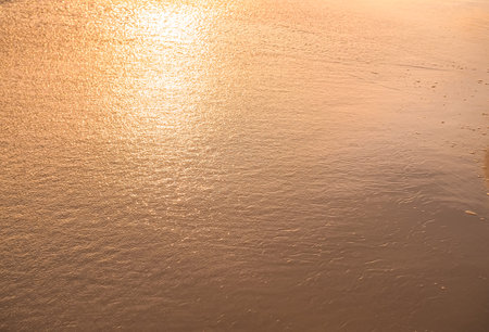 Water and sand at the beach in sunset time