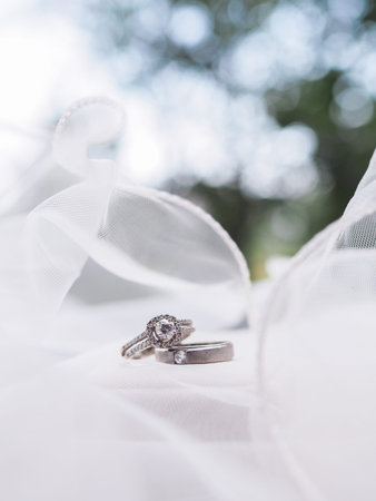 Diamond engagement wedding rings on bridal veil. Wedding accessories. Valentine's day and Wedding day concept.の写真素材