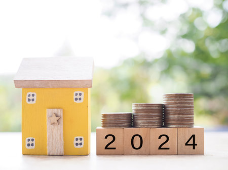Miniature house, Wooden blocks with number 2024 and stack of coins. The concept of Property...