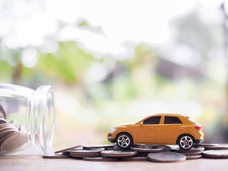 Toy car on stack of coins. The concept of saving money and manage to success transport businessの写真素材