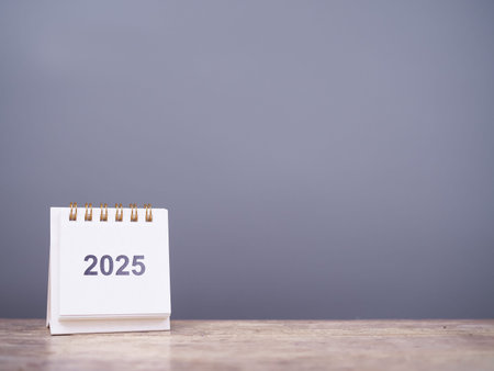 Close up 2025 desk calendar on the table with copy space. Resolution, Goal, Action, Planning, and...