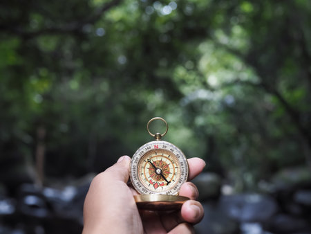 Hand holding compass with nature background. The concept of world tourism day, Searching the right directions and Travelの写真素材
