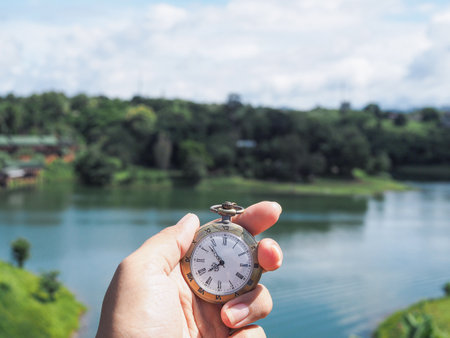 Close up of vintage pocket watch in woman hand with nature as background.の写真素材