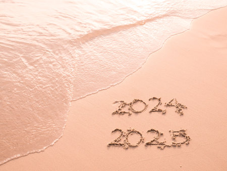 Handwritten inscription 2024 and 2025 on the beach in the sunset time. The concept of Goodbye 2024...