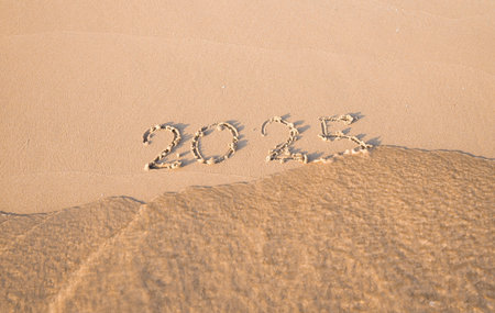 2025 year handwritten on the beach in the sunset time. New Year 2025 concept