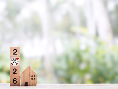 Wooden block with number 2026 and miniature house. The concept of Property investment, House...
