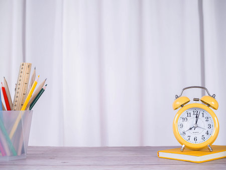 Creative desk, Yellow alarm on hardcover book and colorful stationery. Copy space for text, Office...