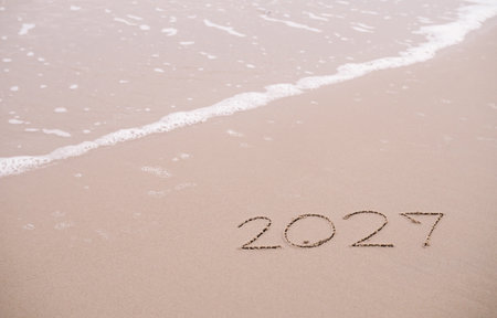 2027 year handwritten on the beach in the sunset time. New Year 2027 conceptの写真素材