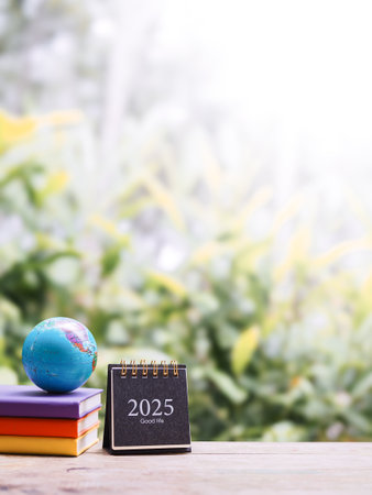 Student creative desktop, Earth globe on hardcover book and 2025 desk calendar. Copy space for text, Back to school, Education conceptの写真素材