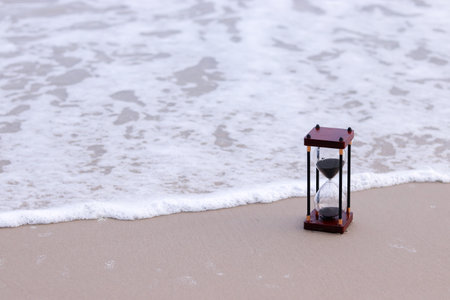 Hourglass on the beach. The concept about countdown to Summer, Travel, Vacation and Relaxation.の写真素材