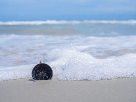 Compass with ocean waves on a sandy beach. The concept of world tourism day, Searching the right directions and Travelの写真素材