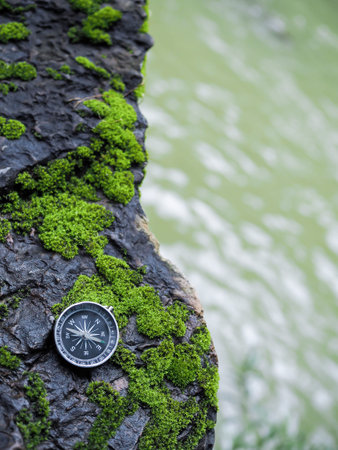 Compass on the rock with water as background. The concept of world tourism day, Searching the right...