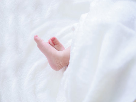Close up of newborn baby feet on white blanketの写真素材