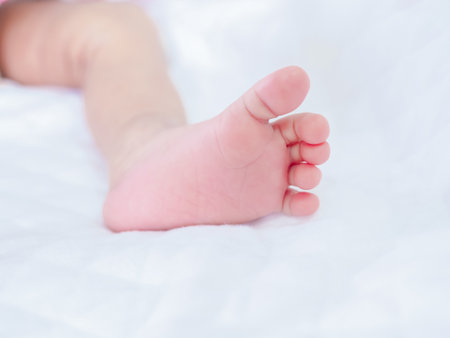 Close up of newborn baby feet on white blanketの写真素材