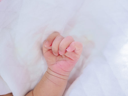 Close up of newborn baby hand  on white blanketの写真素材