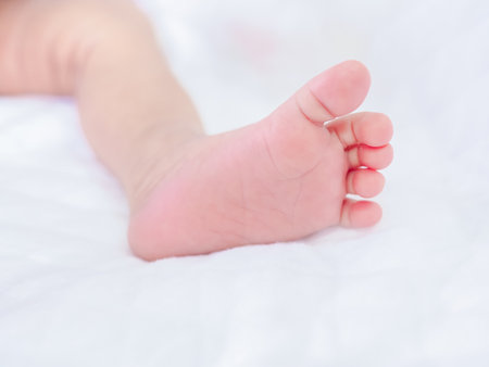 Close up of newborn baby feet on white blanketの写真素材